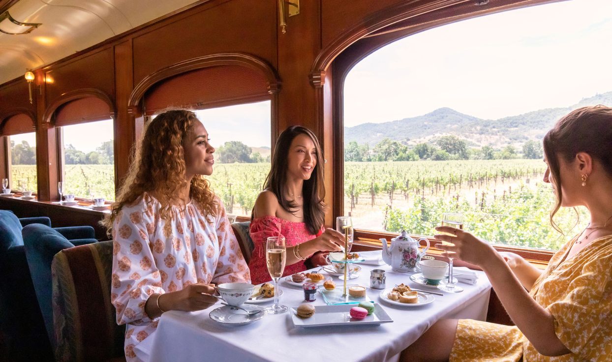 Three woman conversing over dinner with wine